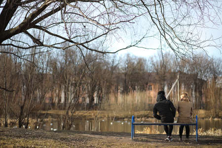 A couple of friends sitting on a bench in the parkの写真素材