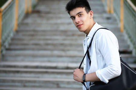 A young man standing on the stairs in the city parkの写真素材