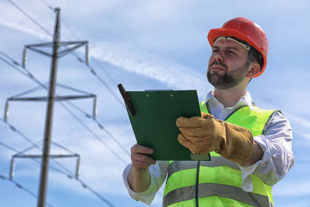 An electrician wearing a helmet and gloves workingの写真素材