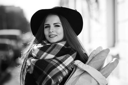 A black and white photo of a young girl going for a walk in the city park