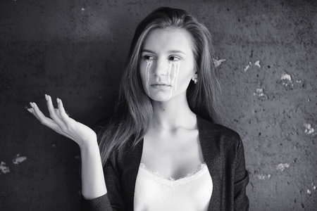 Beautiful girl with tears in her eyes. Young girl with painted tearsの写真素材