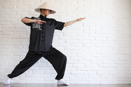 Asian young novice on a white brick wall