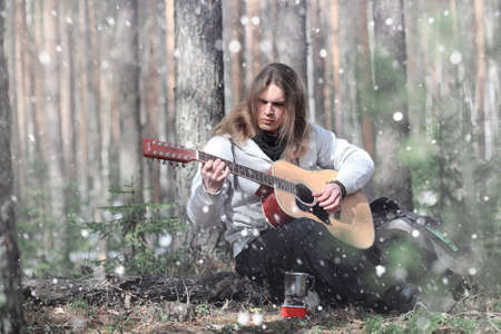 Guitarist in the woods at a picnic. A musician with an acousticの写真素材