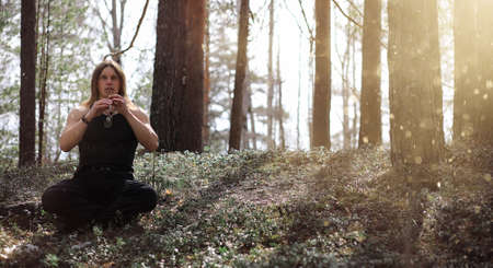 A musician with a tool in nature. A man is playing a flute in aの写真素材