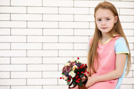 little girl is sitting on a chairの写真素材