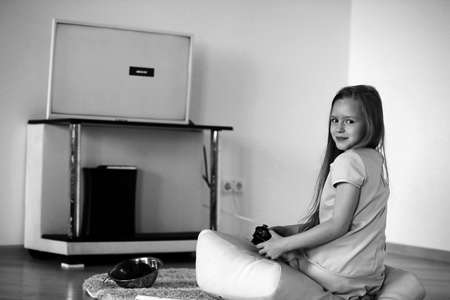 Girl playing in front of the TVの写真素材