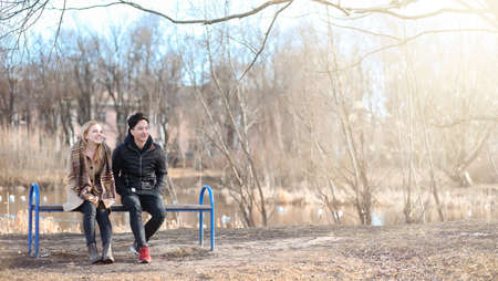 A pair of young people met in the park. Lovers are sitting on aの写真素材