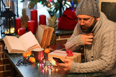 beard man writing christmas gifts on a table