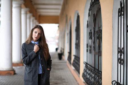 Young beautiful girl on a walk near building with a columnの写真素材