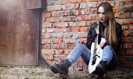 Beautiful young girl rocker with electric guitar. A rock musiciaの写真素材