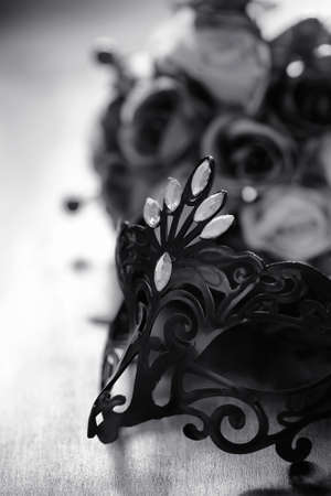 Carnival mask on the table. The subject of camouflage on date during a carnival. Venetian mask on a wooden table in black and white.
の写真素材