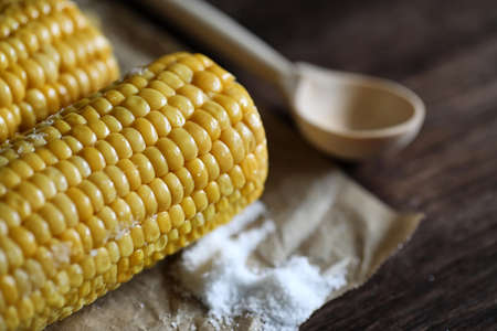 Boiled corn cob with salt on a woodの写真素材