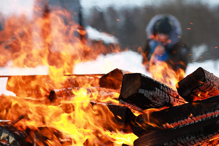 Dry wooden logs burn with a bright flame in the fireの写真素材