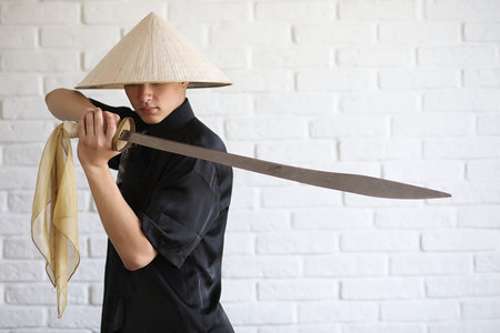 Asian young novice on a white brick wall