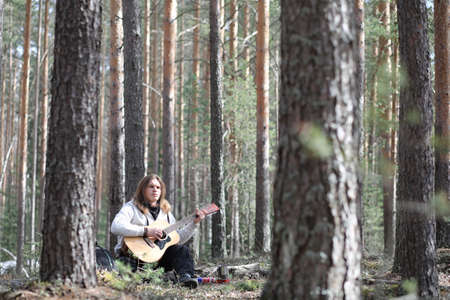 Guitarist in the woods at a picnic. A musician with an acousticの写真素材