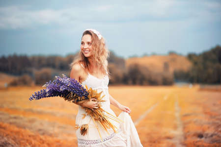 Girl with a bouquet of flowers in autumnの写真素材