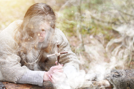 A man in a cassock spends a ritual in a dark forestの写真素材