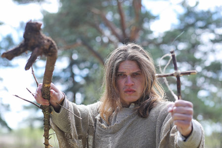 A man in a cassock spends a ritual in a dark forestの写真素材