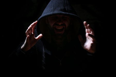 Man in a black hood and smoke