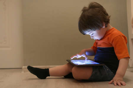 Young kid playing on a floor in a roomの写真素材