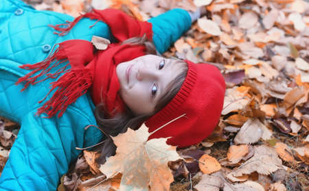 Girl in autumn city park in leaf fall. Young beautiful mother wiの写真素材