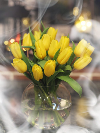 A bouquet of yellow tulips in a vase in the interior of a retro