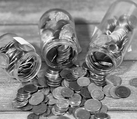 Coins in a jar on the floor. Accumulated coins on the floor. Savの写真素材