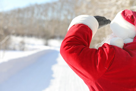 Santa Claus comes with gifts from the outside. Santa in a red suの写真素材