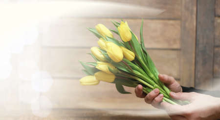 bouquet of yellow tulips in a vase on the floorの写真素材