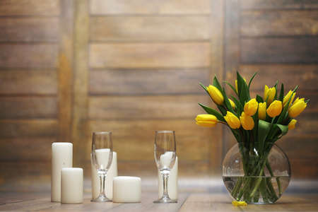 A bouquet of yellow tulips in a vase on the floor. A gift to a wの写真素材