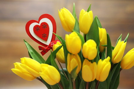 A bouquet of yellow tulips in a vase on the floor. A gift to a wの写真素材