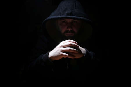 Man in a black hood and smokeの写真素材