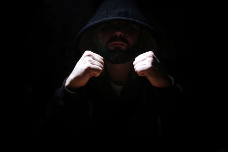 Man in a black hood and smokeの写真素材