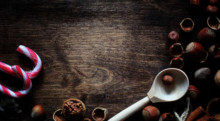 Nuts on a wooden table. Hazelnuts in the shells and shelled. A wooden spoon and nuts on brown table.の写真素材