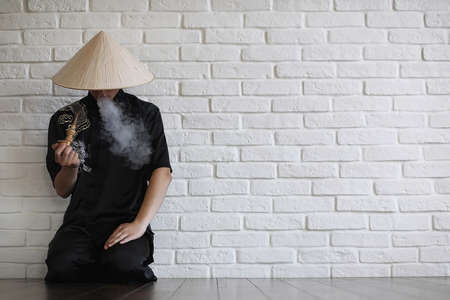 Asian young novice on a white brick wall backgroundの写真素材