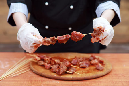 The cook cuts meat for cooking barbecue on the tableの写真素材