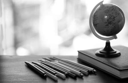 A pen on the desk and a small blue globeの写真素材