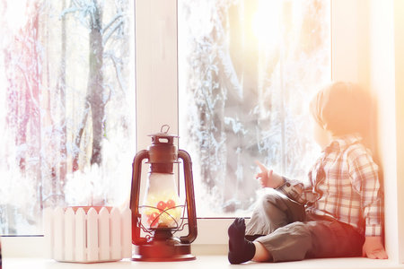 A child in the new year looks out the window. Children are waitiの写真素材