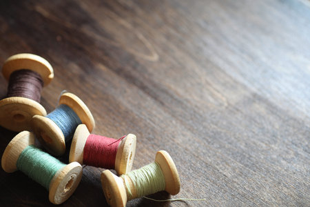 Sewing thread on a wooden background. Set of threads on bobbins