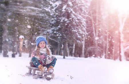 A winter fairy tale, a young mother and her daughter ride a sled