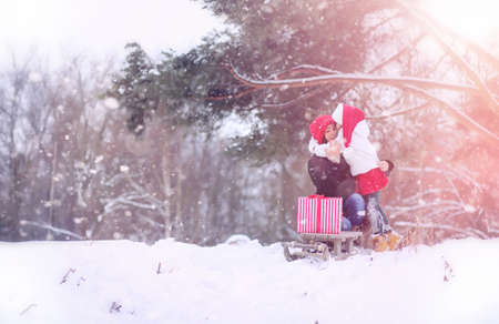A winter fairy tale, a young mother and her daughter ride a sledの写真素材