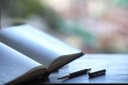 open book and a table in front of the windowの写真素材