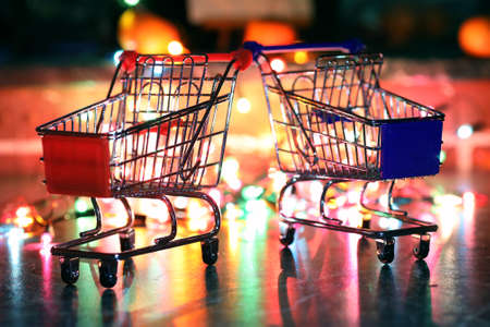 metal supermarket small cart on a background colored lightsの写真素材