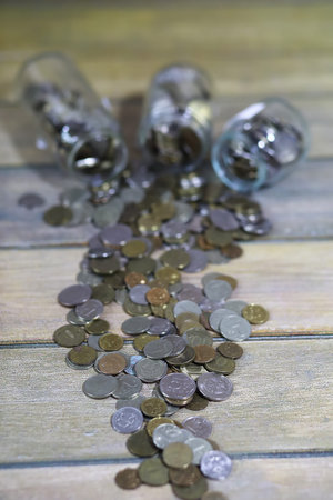 Accumulated coins stacked in glass jarsの写真素材