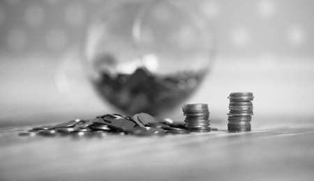 Coins in a jar on the floor. Accumulated coins on the floor. Savの写真素材