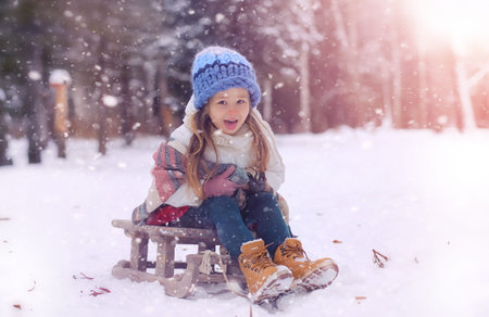 A winter fairy tale, a young mother and her daughter ride a sled