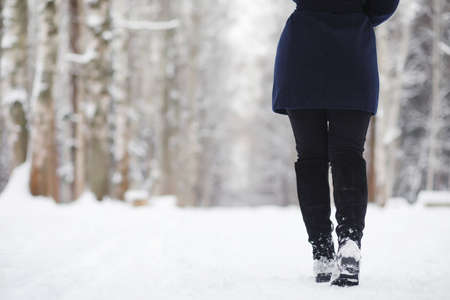 A young girl in a winter park on a walk.の写真素材