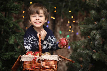 A little child by the New Year tree. Children decorate the Chrisの写真素材