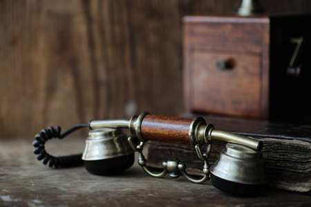 Old telephone and retro book on a woodの写真素材