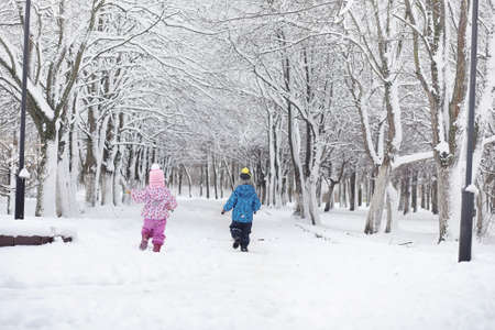 Snow-covered winter park and benches. Park and pier for feeding ducks and pigeons.Family on a walk in the snow covered the autumn park.
の写真素材